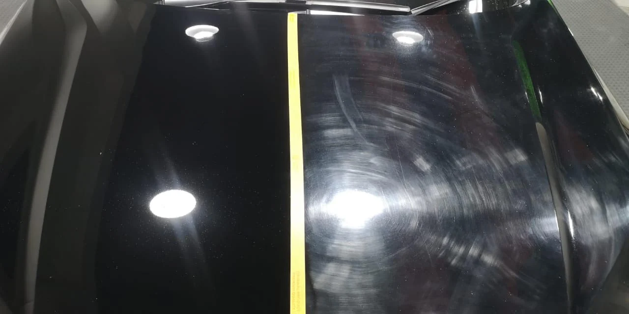 Black bonnet split by tape: polished on the left, swirled on the right